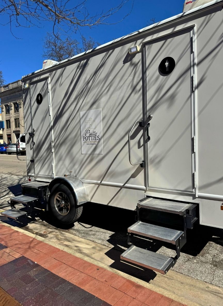 Pretty Potties bathroom trailer with two women's stalls and two men's stalls.